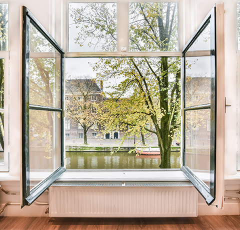 open window overlooking a canal with autumn trees and a gentle breeze ideal for relaxation and home ambiance