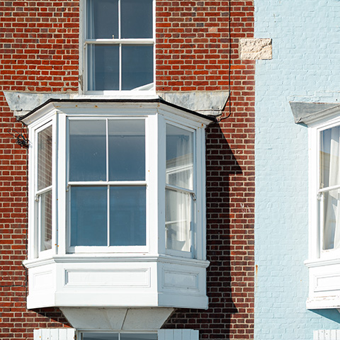 white bay window on red brick wall with blue side houses 22 features and design elements
