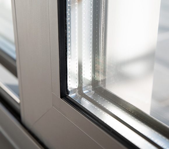 close up of a modern window frame with clear glass featuring a sleek design and silicone seal ideal for energy efficiency in residential or commercial buildings 12 energy savings options