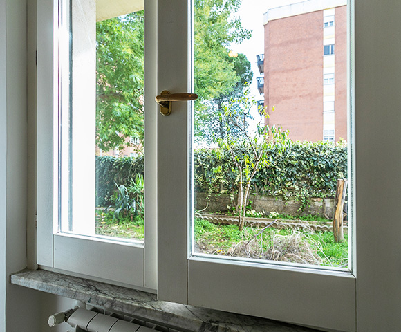view of outdoor garden through a window with plants and trees visible showcasing natural light and 3 attractive features of the landscape